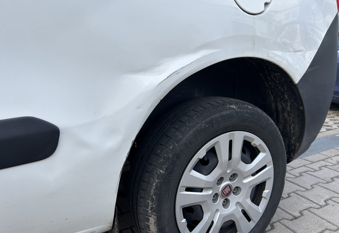 Eingedrückte hintere Seitenwand und aufgerissener Radlauf eines weißen Fiat Doblò Kastenwagens, Schadenhöhe 8.397,85 €